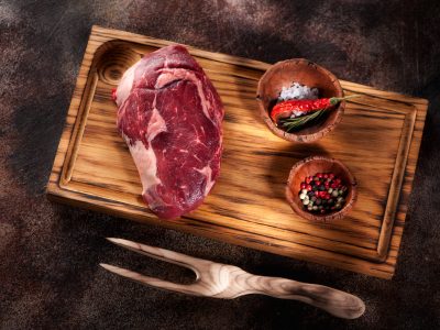 Raw fresh meat Ribeye Steak on a brown rusty background top view